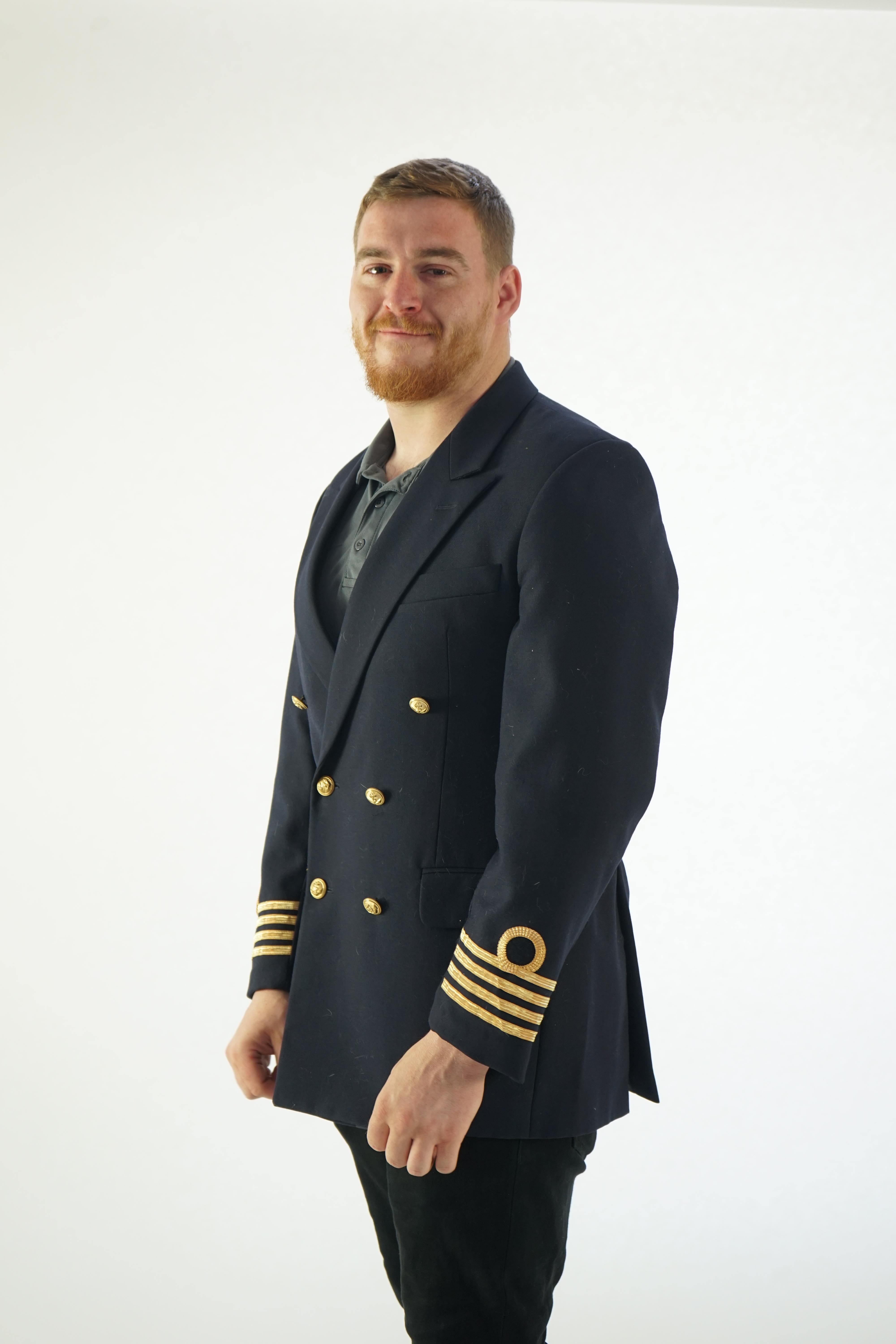 A modern naval style black-navy uniform jacket with gold trim.